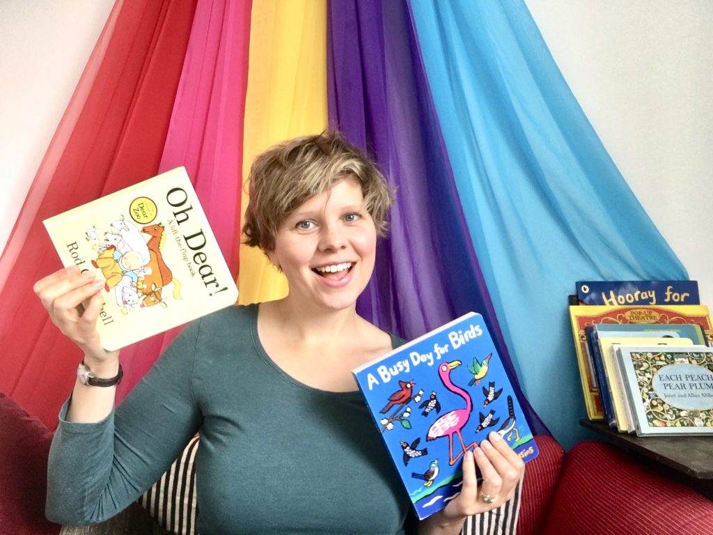 Woman smiling and holding children's books