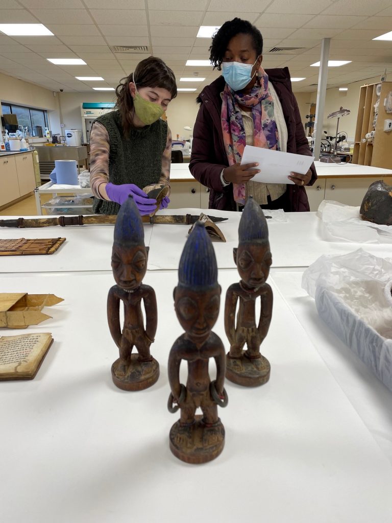 Raquel McKee from the African Caribbean Support Organisation Northern Ireland (ACSONI) advising on African material in the national Contents ← collection, with Bethany Skuce, National Museums NI Object Conservator