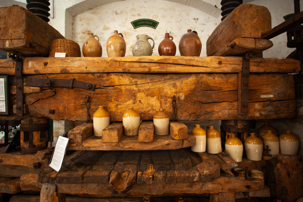 A wooden shelf featuring antique pottery