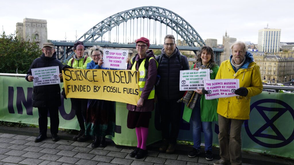 A group of protesters in Newcastle-Gateshead with a bridge in the background