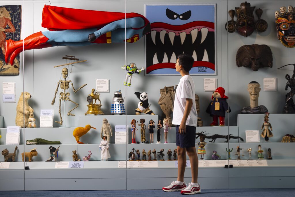 Boy in white tshirt and shorts looks at displays of toys